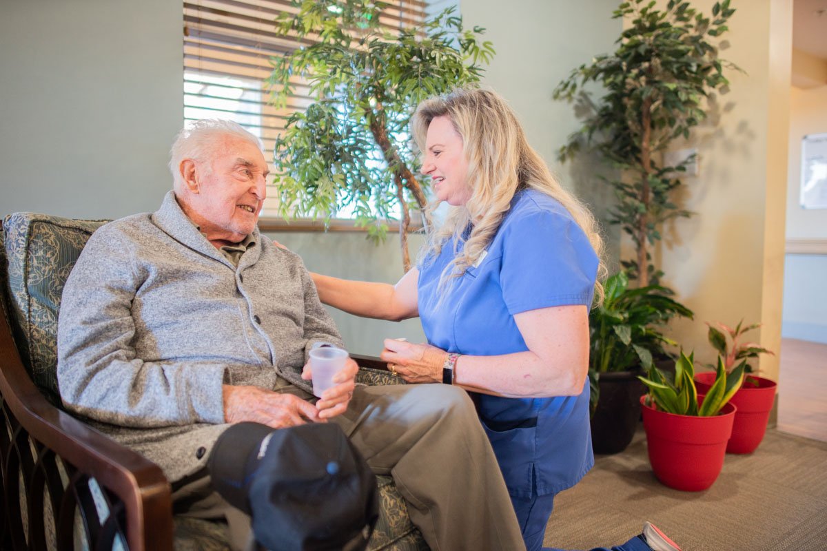 Caregiver Gives Senior Man Water and Medication_The Pavilion Senior Living