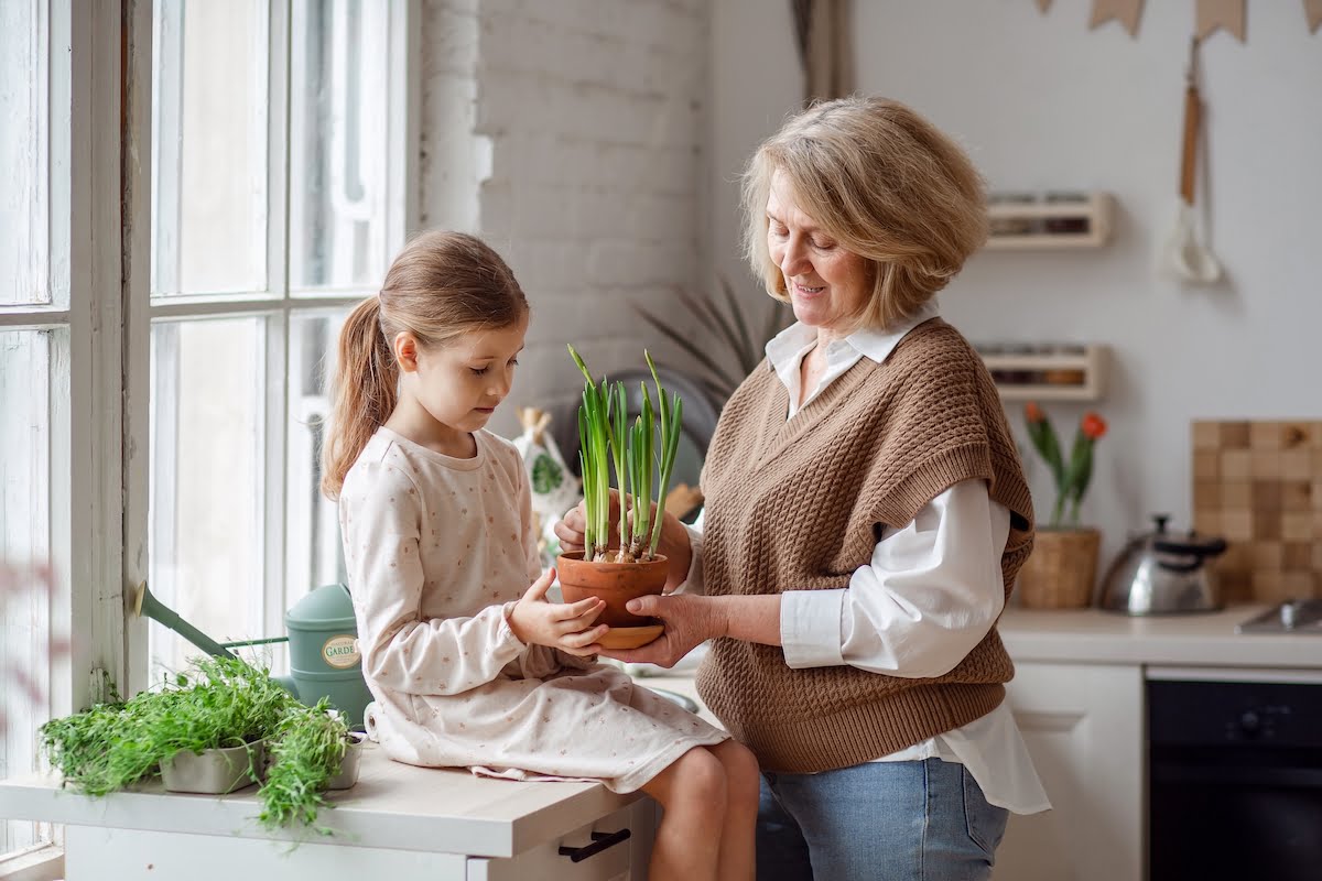 Senior Woman Teaching Granddaughter How to Care For Potted Plant_The Pavilion Senior Living